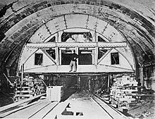A tunneling machine inside an unfinished arched chamber