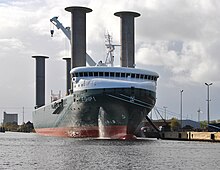 A cargo ship with four vertical columns rising above its deck
