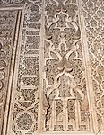 Arabesque and pine cone motifs along with Kufic inscriptions around the mihrab