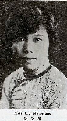 A young Chinese-Tibetan woman with short wavy dark hair, wearing a light-colored top with dark trim