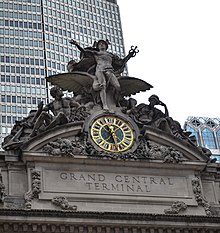 A large clock and stone sculptural group adorning the building's facade