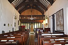 An interior view of the church, showing the balcony, rood screen, pews, pulpit, wall paintings, and the chancel.
