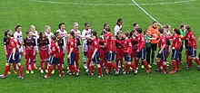 Two teams of players shaking hands.