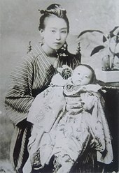 A mother in a kimono holds her newborn child.