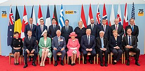 Seated left to right are: Governor-General of New Zealand Patsy Reddy, French president Emmanuel Macron, British prime minister Theresa May, Prince Charles, Queen Elizabetth II, US president Donald Trump, Greek president Prokopis Pavlopoulos, German chancellor Angela Merkel and Dutch prime minister Mark Rutte