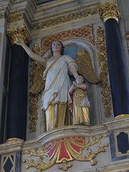 A winged angel holds the hand of a child. Part of the upper section of the Rosary altarpiece