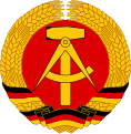 The National emblem of East Germany, a compass, hammer and circle of rye.