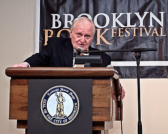 Ashbery speaking at a podium