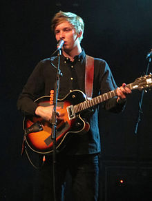 George Ezra holding a guitar