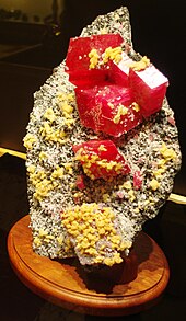 Lump of brown rock with red rectangular crystals protruding out