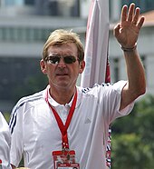 Kenny Dalglish in a white shirt, wearing sunglasses.