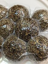 Firm, white shanklish cheese balls covered in spices in a vacuum-sealed bag.