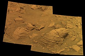 Figure 5. Blocks of Meridiani sediment in the walls of Concepcion Crater. Concepcion Crater is unusually young (roughly 100,000 years).[24] So the exposed layered sediment surfaces imaged here are some of the freshest, least-weathered sediment layers photographed by Opportunity's Pancam. When viewed full size, these Pancam images (Figures 5 & 6) have just enough resolution to show many small hematite spherules embedded in the sediments. Another higher-resolution camera, the Microscopic Imager, took the best images of the hematite spherules (more below). Image taken on Sol 2147 (2010-02-06).