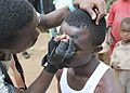 Makeup artist preparing an Atilogu dancer - Igbo Tribe - Oji River - Enugu State - Nigeria