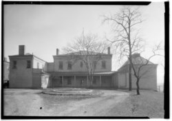 Black-and-white image of a mansion with two wings protruding from its sides