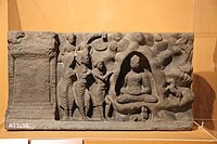 The same scene in a c. 2nd-century relief from Loriyan Tangai, Gandhara. The Buddha is shown in Indrasala cave.