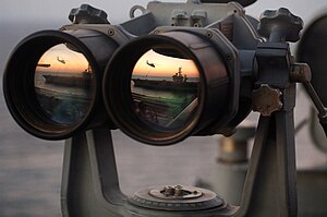 USS Dwight D Eisenhower reflected in binoculars