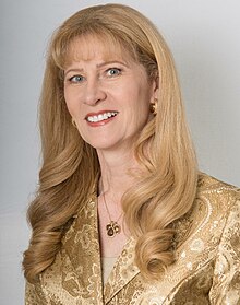 a middle-aged woman with long blonde hair