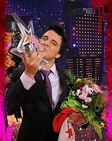 Nader Guirat winner of Star Academy 5 carrying the Tunisian flag and the trophy on stage at the show's finale on 23 May 2008
