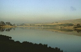 A lake surrounded by low hills