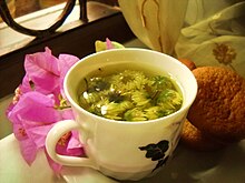 Chrysanthemum blossoms steep in a cup of hot water