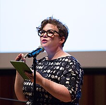 Half-length portrait of Helen Zaltzman speaking into a microphone
