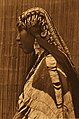 A photograph of a young Wishram woman in bridal garb. Note the Qing dynasty cash coins in her headdress.