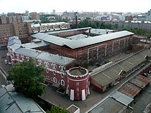 Photograph of a large prison with red walls, surrounded by the city of Moscow