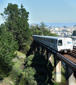 A southbound BART train passes San Francisco's Outer Mission neighborhood, between the Balboa Park station and the Daly City station. The photograph was taken on the pedestrian bridge next to the San Jose/Farallones stop of the SFMTA M line. NOTE: No BART trains stop at San Jose/Farallones.