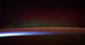 Image 2Earth's night-side upper atmosphere appearing from the bottom as bands of afterglow illuminating the troposphere in orange with silhouettes of clouds, and the stratosphere in white and blue. Next the mesosphere (pink area) extends to the orange and faintly green line of the lowest airglow, at about one hundred kilometers at the edge of space and the lower edge of the thermosphere (invisible). Continuing with green and red bands of aurorae stretching over several hundred kilometers. (from Earth)