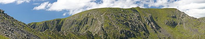 A panoramic view of the ascent of Helvellyn with Striding Edge on the left, then a steep scramble to the summit followed by a scrambling descent via Swirrel Edge on the right, leading to Catstye Cam.
