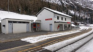 Two-story building with gabled roof; snow has fallen on the platforms