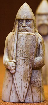Photograph of an ivory gaming piece depicting an armed warrior