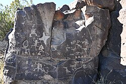 A large collection of petroglyphs on a rock, 2023