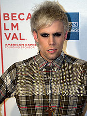 A color photograph of American singer-songwriter Justin Tranter, who is posing in front of a stand and repeat at a 2009 film festival.