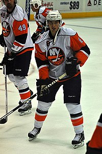 Bruno Gervais holding his hockey stick and skating around fellow team members.