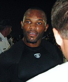 Fred Taylor in a black shirt from the chest up, looking slightly to the side.