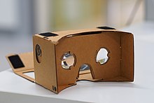 A Google Cardboard headset, photographed on a table in shallow depth of field.
