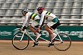 Australian Paralympic athletes using a two-seated tandem racing bicycle; the visually impaired cyclist pedals in rear, while a sighted "pilot" sits in the front.