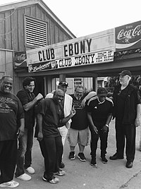 A black-and-white photo of Steve Azar and The King's Men, standing in front of a sign reading "Club Ebony" and "Coca-Cola".
