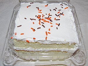 White layer cake with white frosting and colored sprinkles