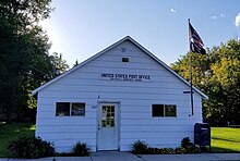 Small white wooden building. The sign reads "United States Post Office, Nielsville, Minnesota 56568".