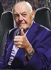 Bud Grant wearing a purple suit and giving a thumbs-up.