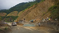 A rural road next to several hills is being upgraded in Lai Chau Province.