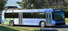 a blue 40 ft bus in an American suburb