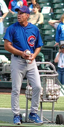 A man in a blue baseball jersey and cap and gray pants