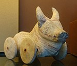 A figurine of a buffalo with wheels, from archaic Greece
