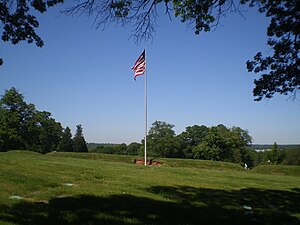 All that remains of Fort Lincoln is the flag, earthenworks, and three cannons at Fort Lincoln Cemetery, Colmar Manor, Maryland. The Old Spring House is off to the left.
