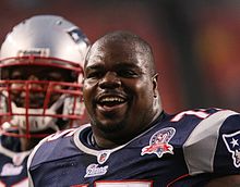 Vince Wilfork from the shoulders up wearing a Patriots jersey with no helmet on.