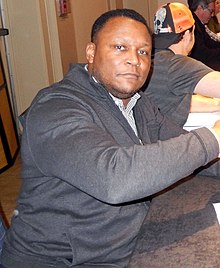 Barry Sanders sitting at a table.
